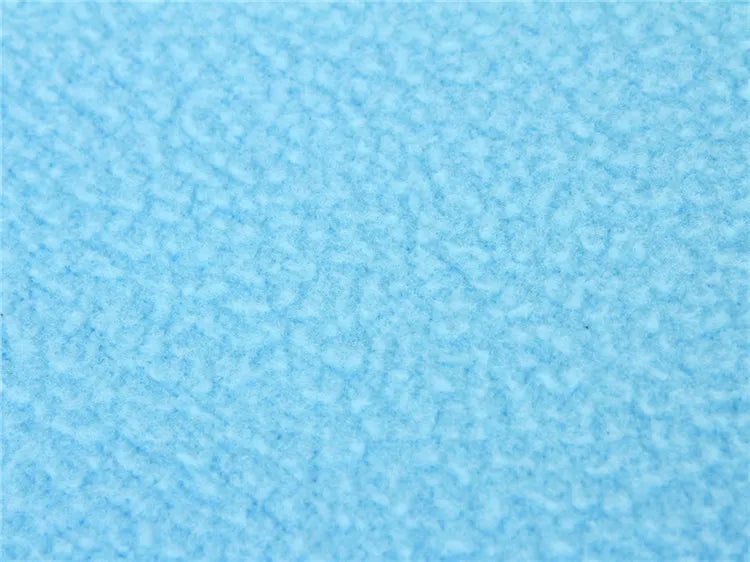 A close-up texture shot of a light blue, pebbled or textured material, likely faux leather or a similar fabric.